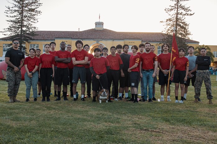 U.S. Marine Corps Lance Cpl. Bruno, the Marine Corps Recruit Depot San Diego and Western Recruiting Region mascot, poses for a photo with Marines and prospective applicants from the San Diego area before the 2024 Marine Corps Recruit Depot San Diego Boot Camp Challenge at MCRD San Diego, California, Oct. 19, 2024. For the past 23 years, MCRD San Diego has hosted the Boot Camp Challenge, a three-mile obstacle course race guided by 60 drill instructors that highlights the physical and mental demands of bootcamp. The event fosters comradery and community engagement through interaction with MCRD personnel. (U.S. Marine Corps photo by Cpl. Sarah M. Grawcock)
