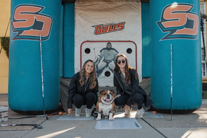 U.S. Marine Corps Lance Cpl. Bruno, the Marine Corps Recruit Depot San Diego and Western Recruiting Region mascot, poses for a photo with the San Diego Gulls hockey team event workers during the 2024 Marine Corps Recruit Depot San Diego Boot Camp Challenge at MCRD San Diego, California, Oct. 19, 2024. For the past 23 years, MCRD San Diego has hosted the Boot Camp Challenge, a three-mile obstacle course race guided by 60 drill instructors that highlights the physical and mental demands of bootcamp. The event fosters comradery and community engagement through interaction with MCRD personnel. (U.S. Marine Corps photo by Cpl. Sarah M. Grawcock)
