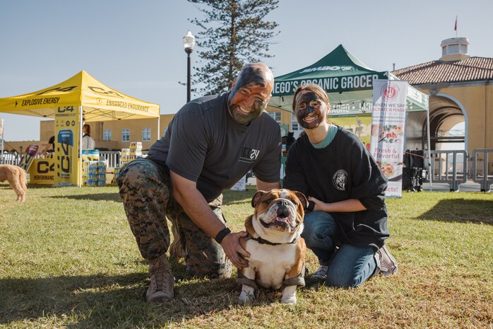 U.S. Marine Corps Col. Jason Freeby, commanding officer of Headquarters and Service Battalion, Marine Corps Recruit Depot San Diego, left, his daughter, right, and Lance Cpl. Bruno, the MCRD San Diego and Western Recruiting Region mascot, pose for a photo during the 2024 Marine Corps Recruit Depot San Diego Boot Camp Challenge at MCRD San Diego, California, Oct. 19, 2024. For the past 23 years, MCRD San Diego has hosted the Boot Camp Challenge, a three-mile obstacle course race guided by 60 drill instructors that highlights the physical and mental demands of bootcamp. The event fosters comradery and community engagement through interaction with MCRD personnel. (U.S. Marine Corps photo by Cpl. Sarah M. Grawcock)