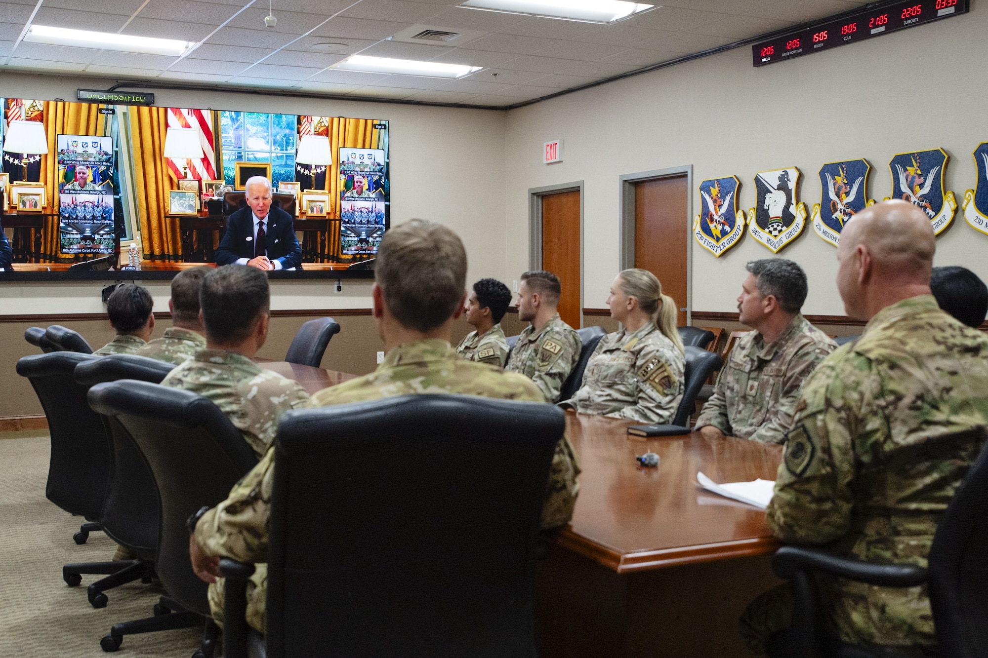 Military members sit around a conference table during a call with the U.S. president
