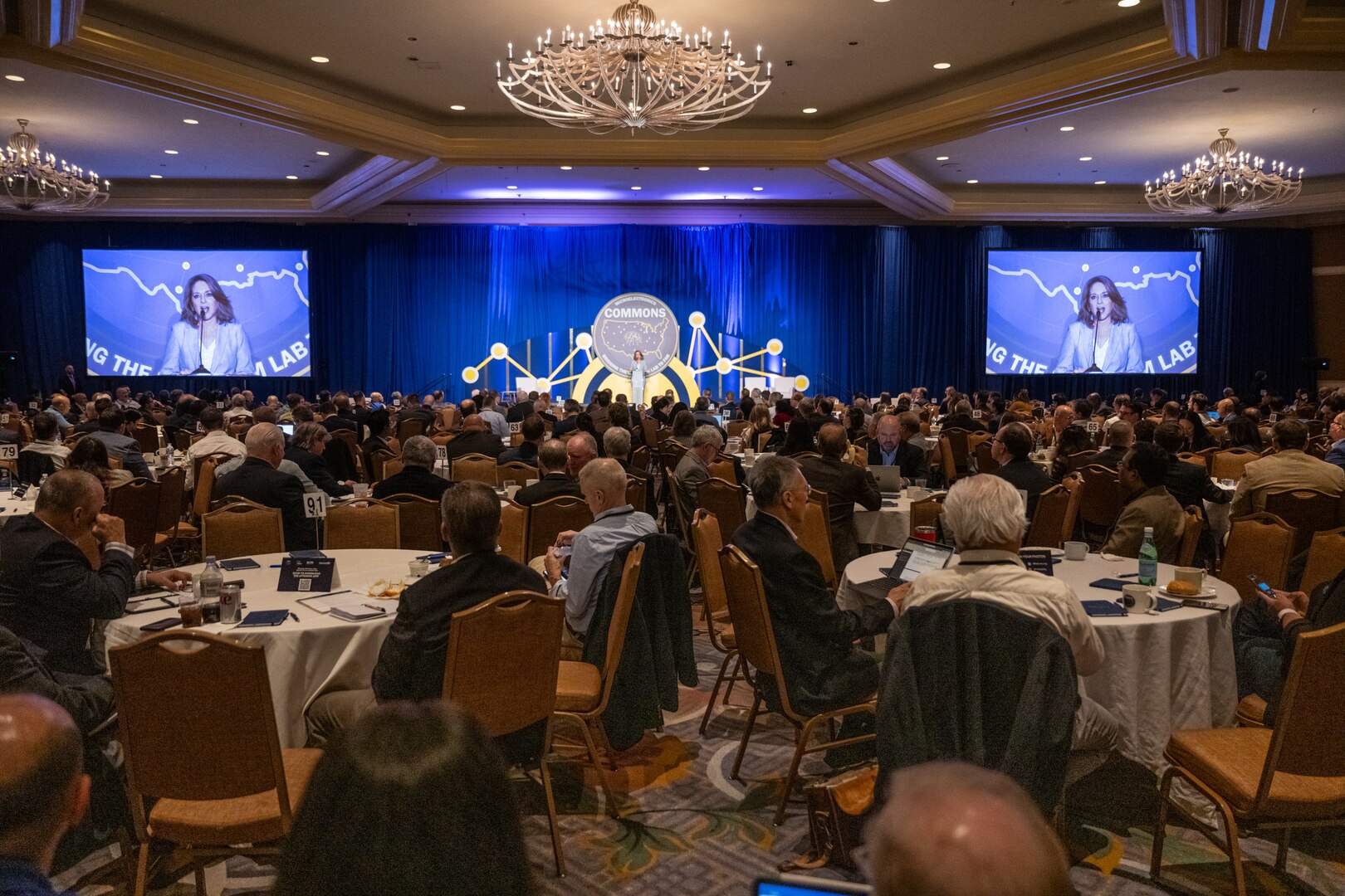 A woman speaks to a large audience.