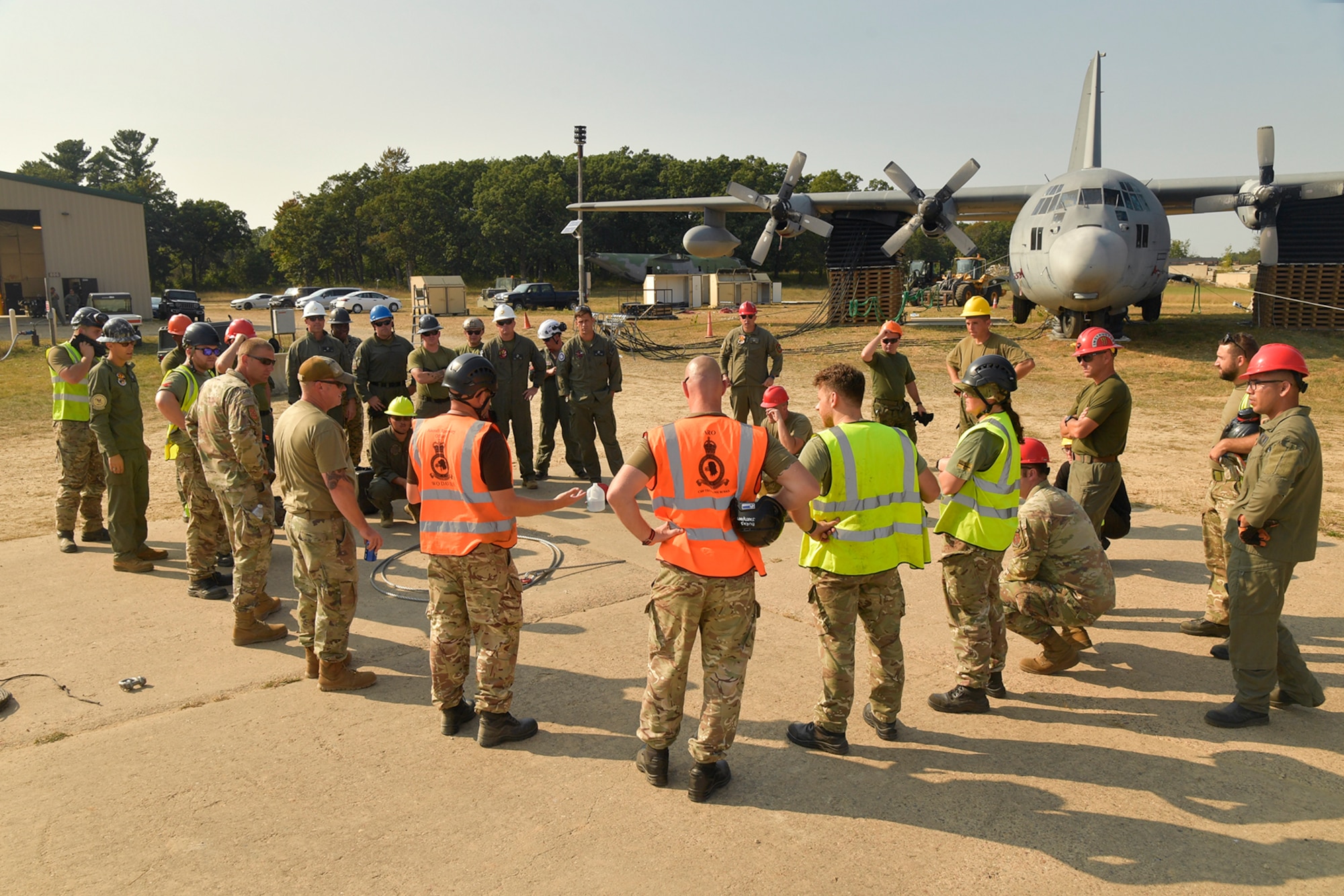 Experienced aircraft recovery personnel from around the world, including participants from the U.S. Air Force, Navy, and Marines, as well as teams from five F-35 foreign partner countries, hotwash after successfully completing airbag-lift procedures on a C-130 training aircraft Sept. 12, 2024, at Volk Field Air National Guard Base, WI. This training, organized by the F-35 Joint Program Office, aimed to share techniques and methodologies, and build international relationships during the advanced CDDAR training exercise for the F-35 global enterprise. (U.S. Air Force photo by Todd Cromar)
