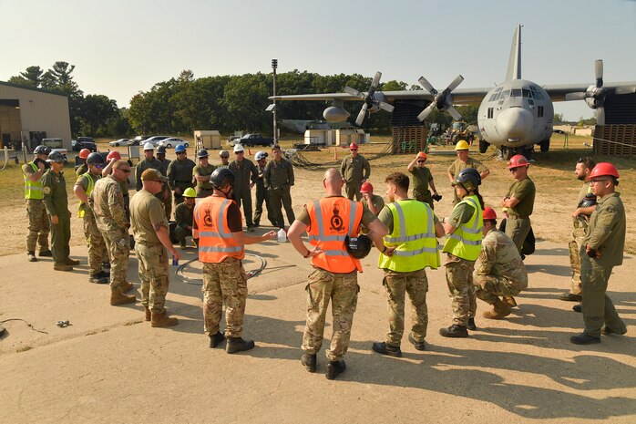 Experienced aircraft recovery personnel from around the world, including participants from the U.S. Air Force, Navy, and Marines, as well as teams from five F-35 foreign partner countries, hotwash after successfully completing airbag-lift procedures on a C-130 training aircraft Sept. 12, 2024, at Volk Field Air National Guard Base, WI. This training, organized by the F-35 Joint Program Office, aimed to share techniques and methodologies, and build international relationships during the advanced CDDAR training exercise for the F-35 global enterprise. (U.S. Air Force photo by Todd Cromar)