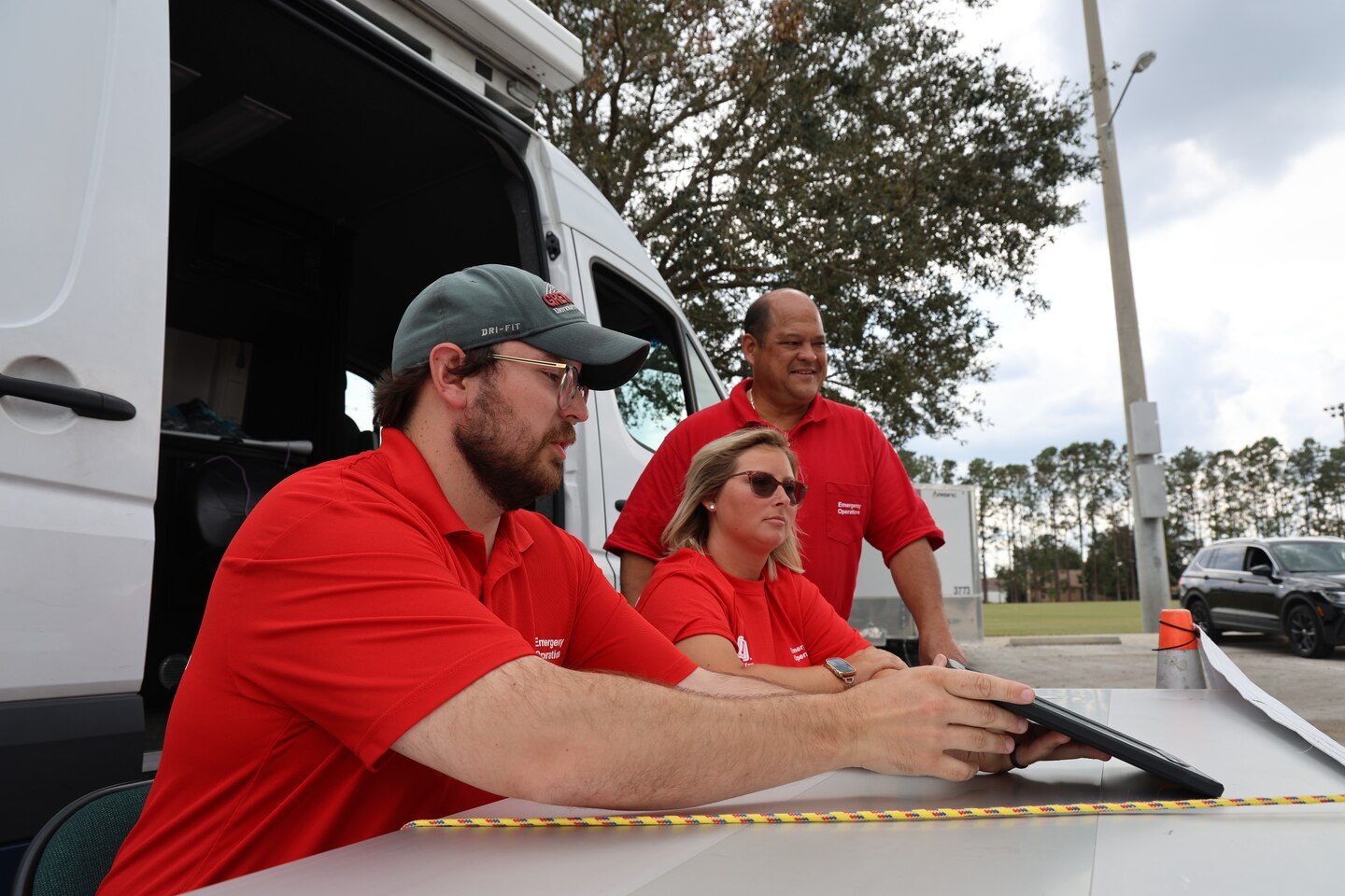 (left to right) U.S. Army Corps of Engineers Ethan Bean, Baltimore District, Katie Blanton, St. Louis District and Rolando Sanidad, Baltimore District assist Polk County residents Bob and Joyce Condie with their Blue Roof application, Oct. 28 at the Lake Myrtle Sports Complex  in Auburndale, Florida. 
(USACE photo by Brook Hubbard IV)
