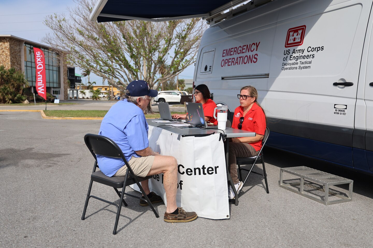 (left to right) U.S. Army Corps of Engineers Omaha District Quality Assurance Specialist Julie Standard and Jenny Schneckloth, assist a Pinellas County resident with their Blue Roof application, Oct. 28 at the Winn Dixie Parking lot, Madeira Beach, Florida. 
 (USACE photo by Brooks O. Hubbard)