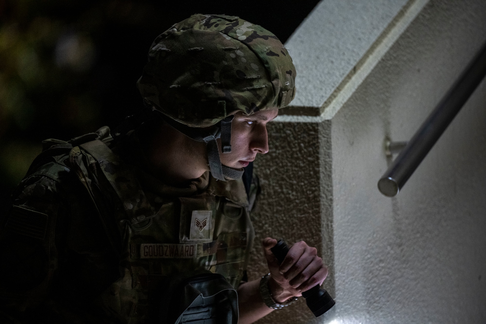 Airman uses flashlight to perform a PAR sweep