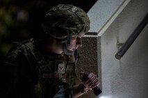 Airman uses flashlight to perform a PAR sweep