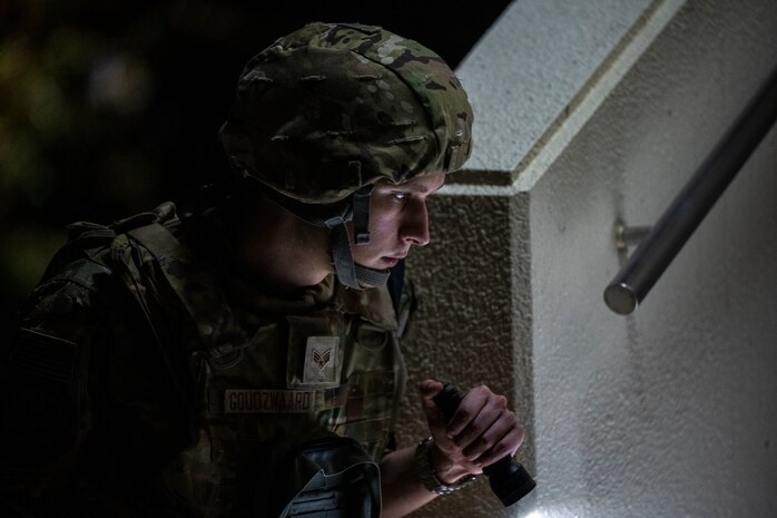 Airman uses flashlight to perform a PAR sweep
