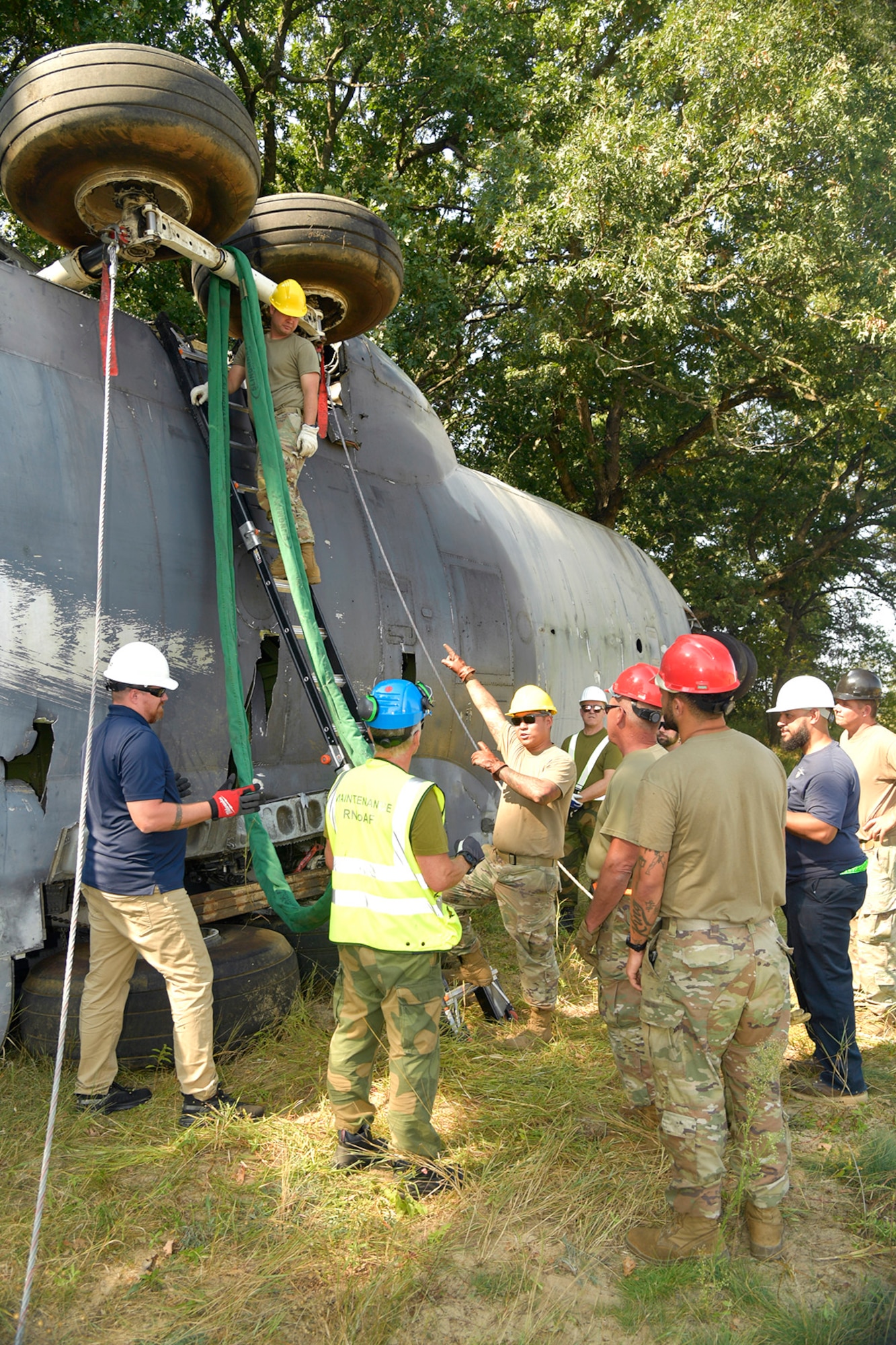 Experienced aircraft recovery personnel from around the world, including participants from the U.S. Air Force, Navy, and Marines, as well as teams from five F-35 foreign partner countries, practice aircraft crane lift-rollover procedures on a C-130 training aircraft Sept. 11, 2024, at Volk Field Air National Guard Base, WI. This training, organized by the F-35 Joint Program Office, aimed to share techniques and methodologies, and build international relationships during the advanced CDDAR training exercise for the F-35 global enterprise. (U.S. Air Force photo by Todd Cromar)