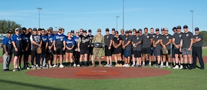 U.S. Air Force Col. Thomas Wilson, 17th Training Wing deputy commander, poses for a group photo with the 17th Security Forces Squadron and 17th Civil Engineering Squadron Fire Department before the Inaugural Battle of the Badges softball game at the Mathis Fitness Center, Goodfellow Air Force Base Texas, Oct. 28, 2024. The firefighters started the game with an extra point because they had one more pint of blood donated by the end of the blood drive. (U.S. Air Force photo by Airman 1st Class Brian Lummus)