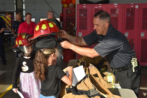 Firefighter puts gear on a student