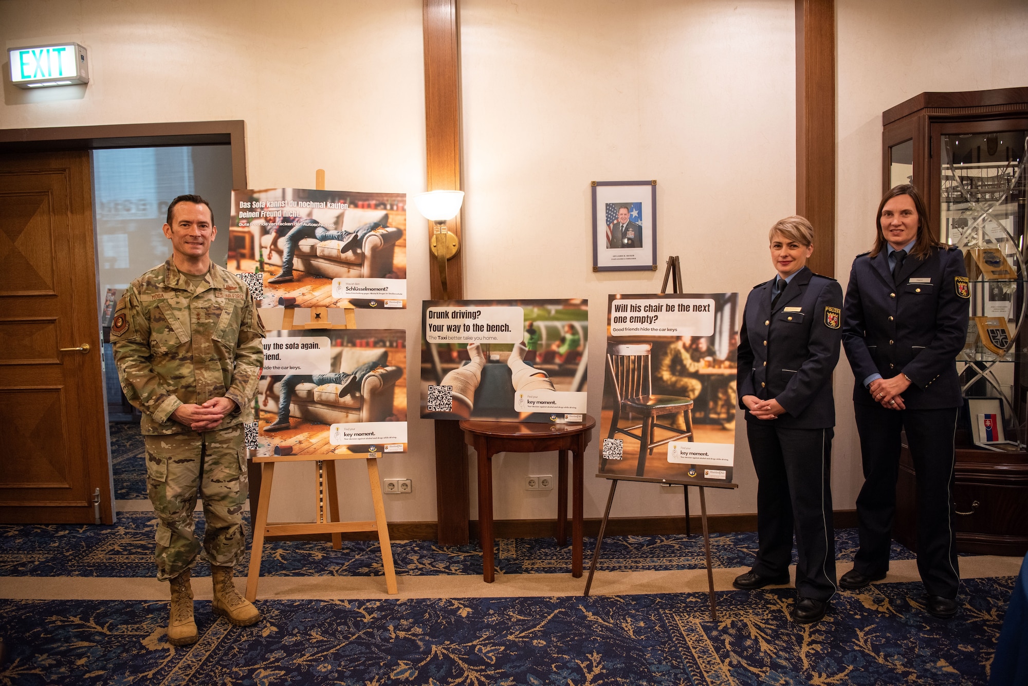 U.S. Air Force Maj. Gen. Paul D. Moga, Third Air Force and Kaiserslautern Military Community commander, Jacqueline Schröder, Head of Police Inspection Pirmasens, and Carolin Henn, Police Presidium West Palatinate chief of staff, unveil “Key Moment” DUI campaign posters during the campaign rollout at Ramstein Air Base, Germany, Oct. 28, 2024.