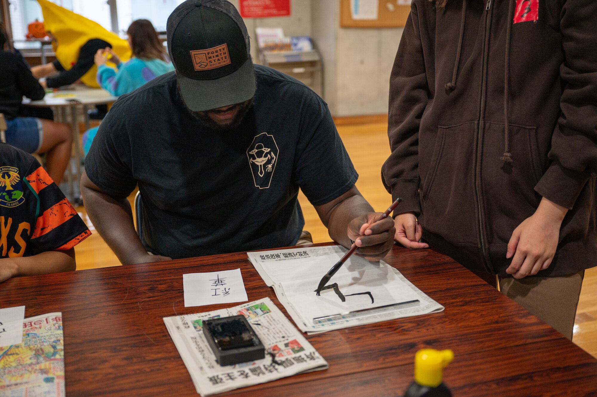 Volunteer writing Kanji during a KLI event