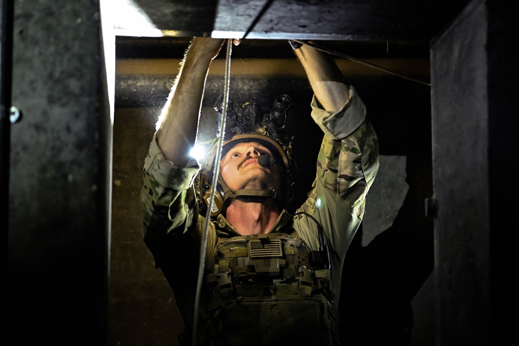 A man in uniform places a rope in a doorway.