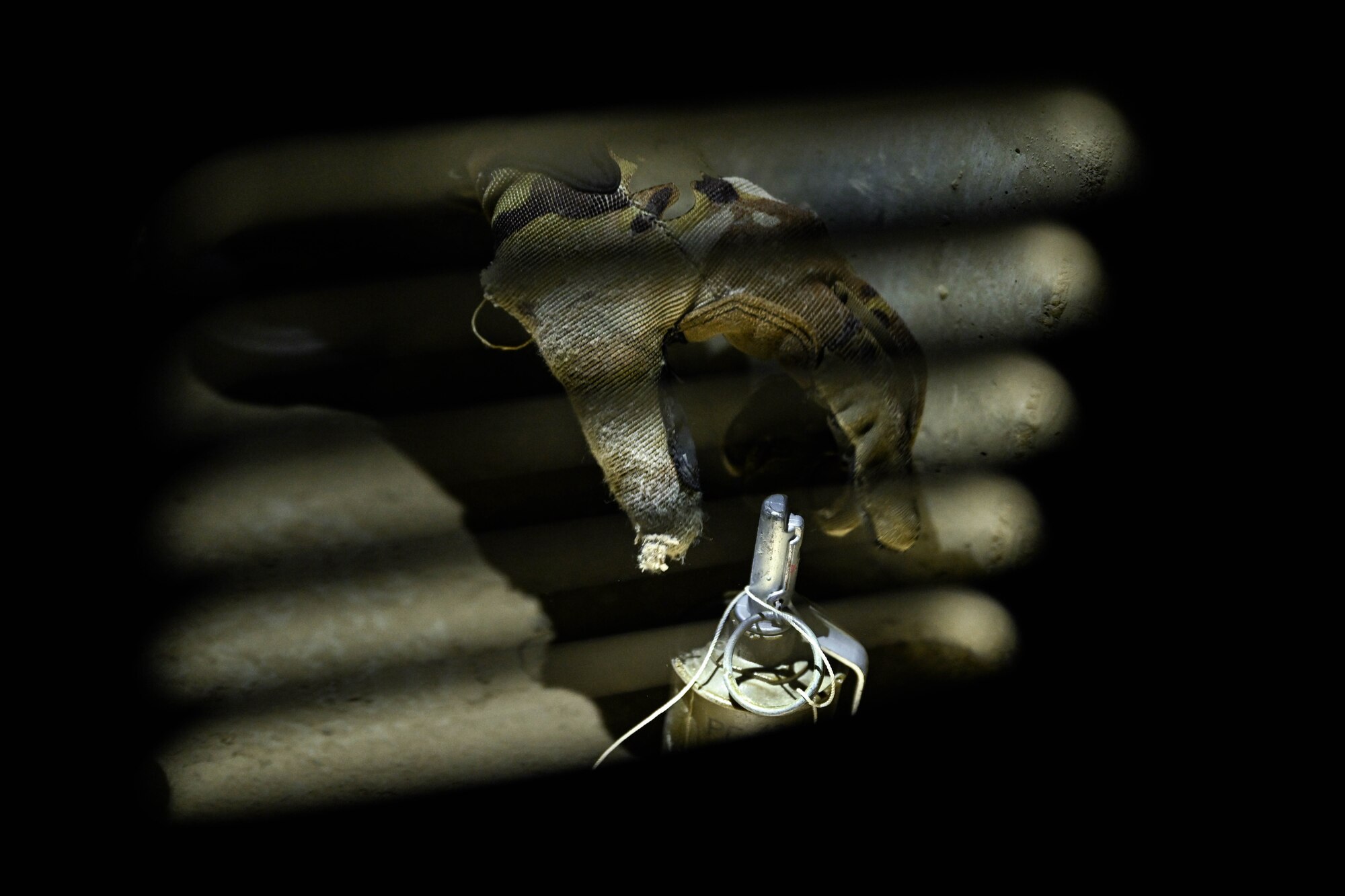 A hand reaches for a simulated grenade.