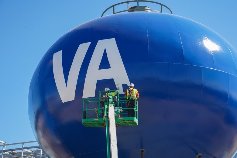 Contractors paint the Veterans Affairs logo on the surface of a water tower at the Louisville VA Medical Center in Louisville, Ky., Oct. 3, 2024.