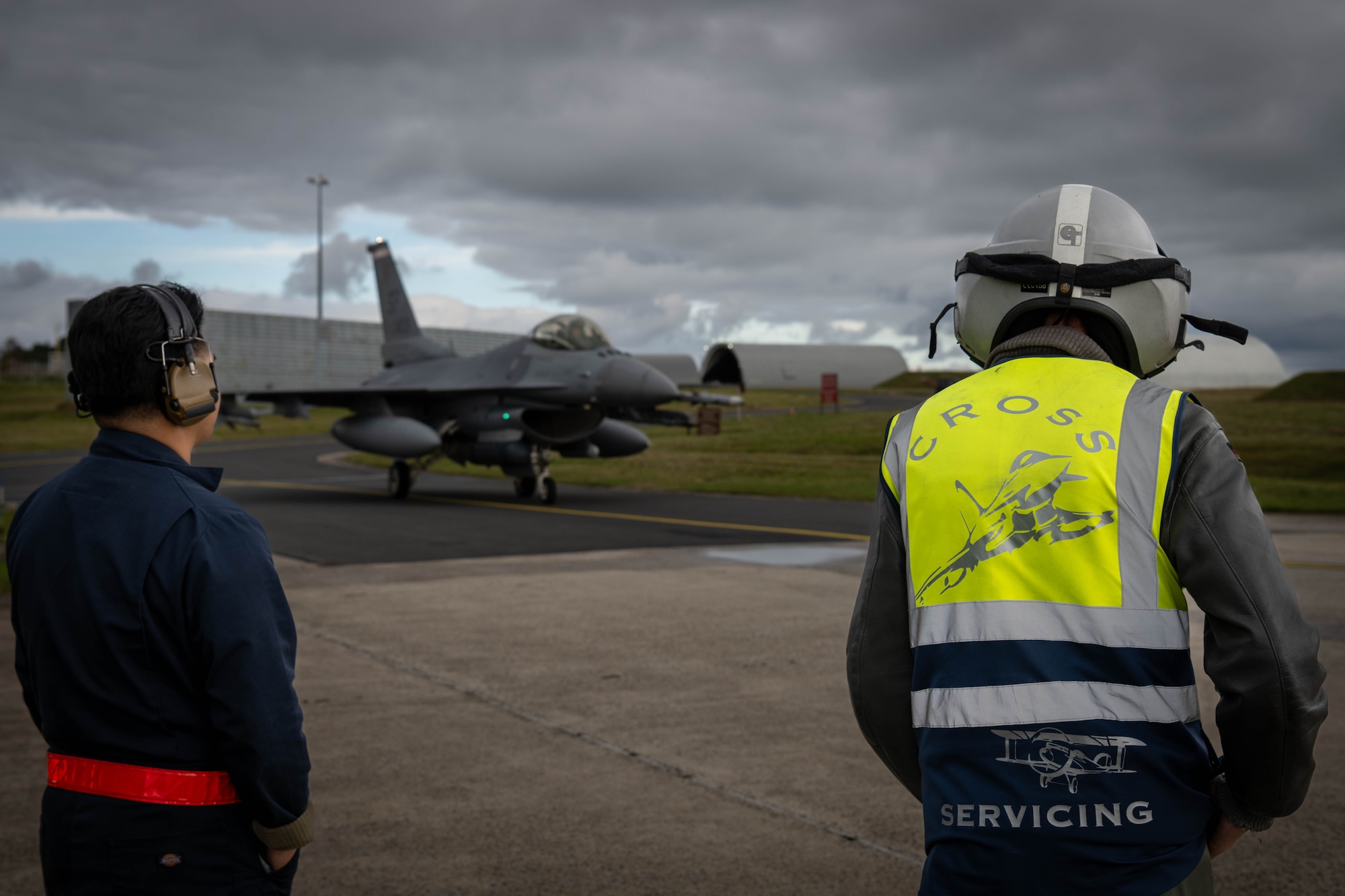 U.S. Air Force crew chief and a German Luftwaffe maintainer wait for a jet.