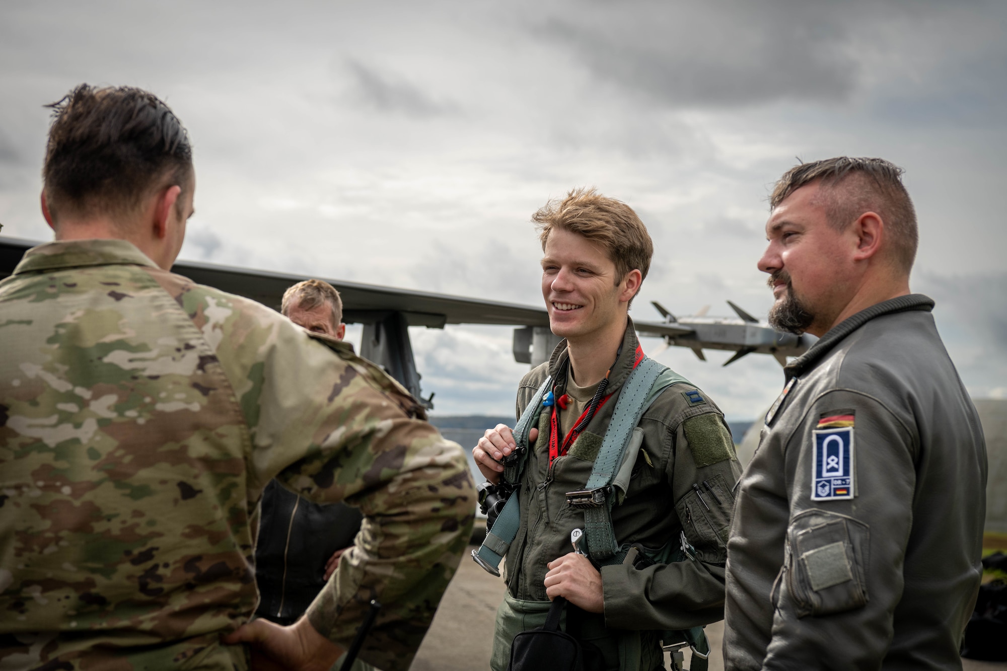 U.S. Air Force F-16 pilot talks to a U.S. Air Force instructor and German Luftwaffe maintainer.
