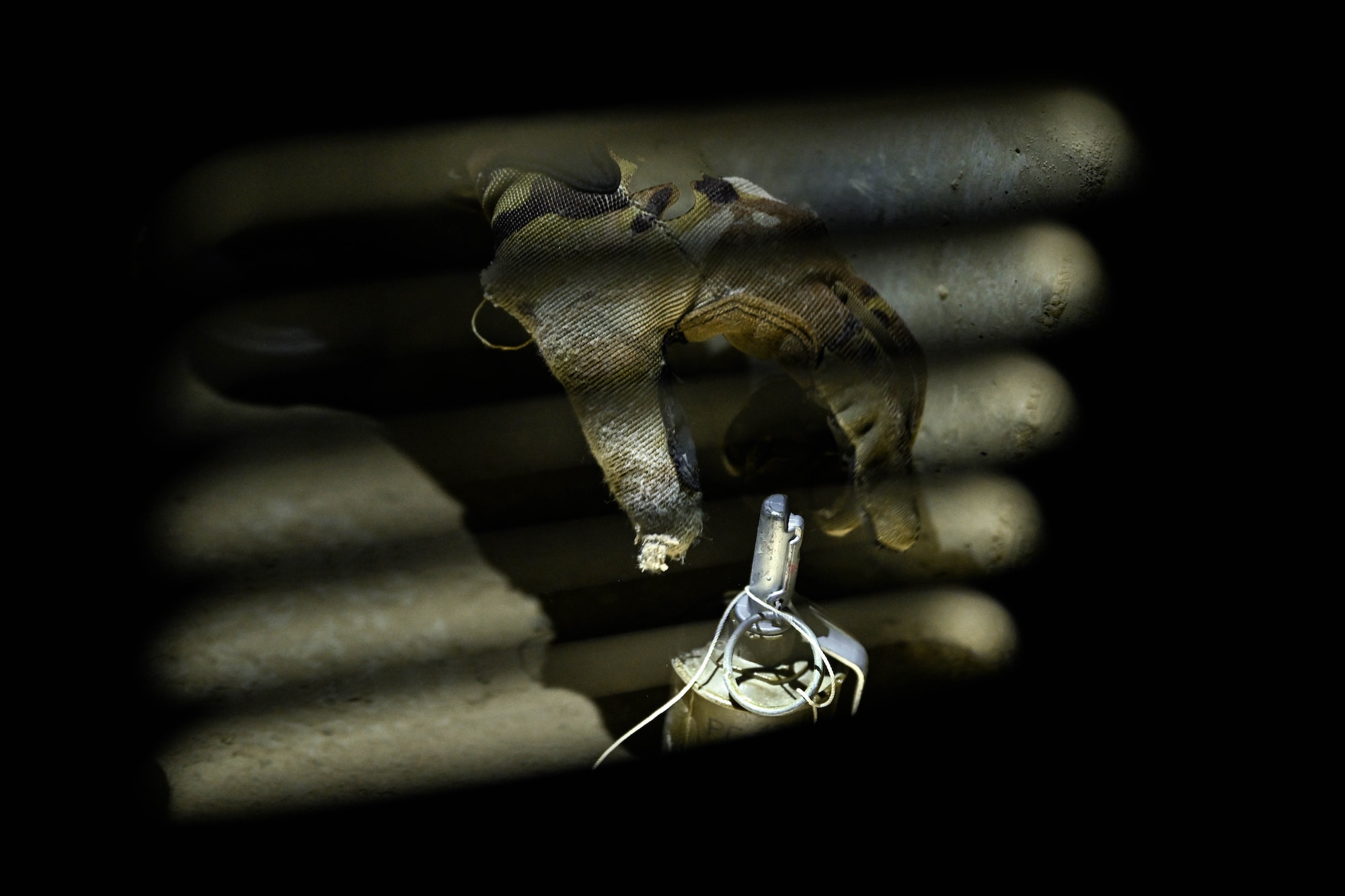 A hand reaches for a simulated grenade.