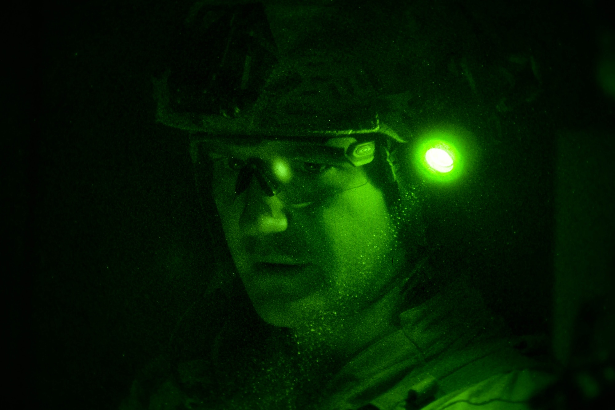 A man wearing a helmet looks down.