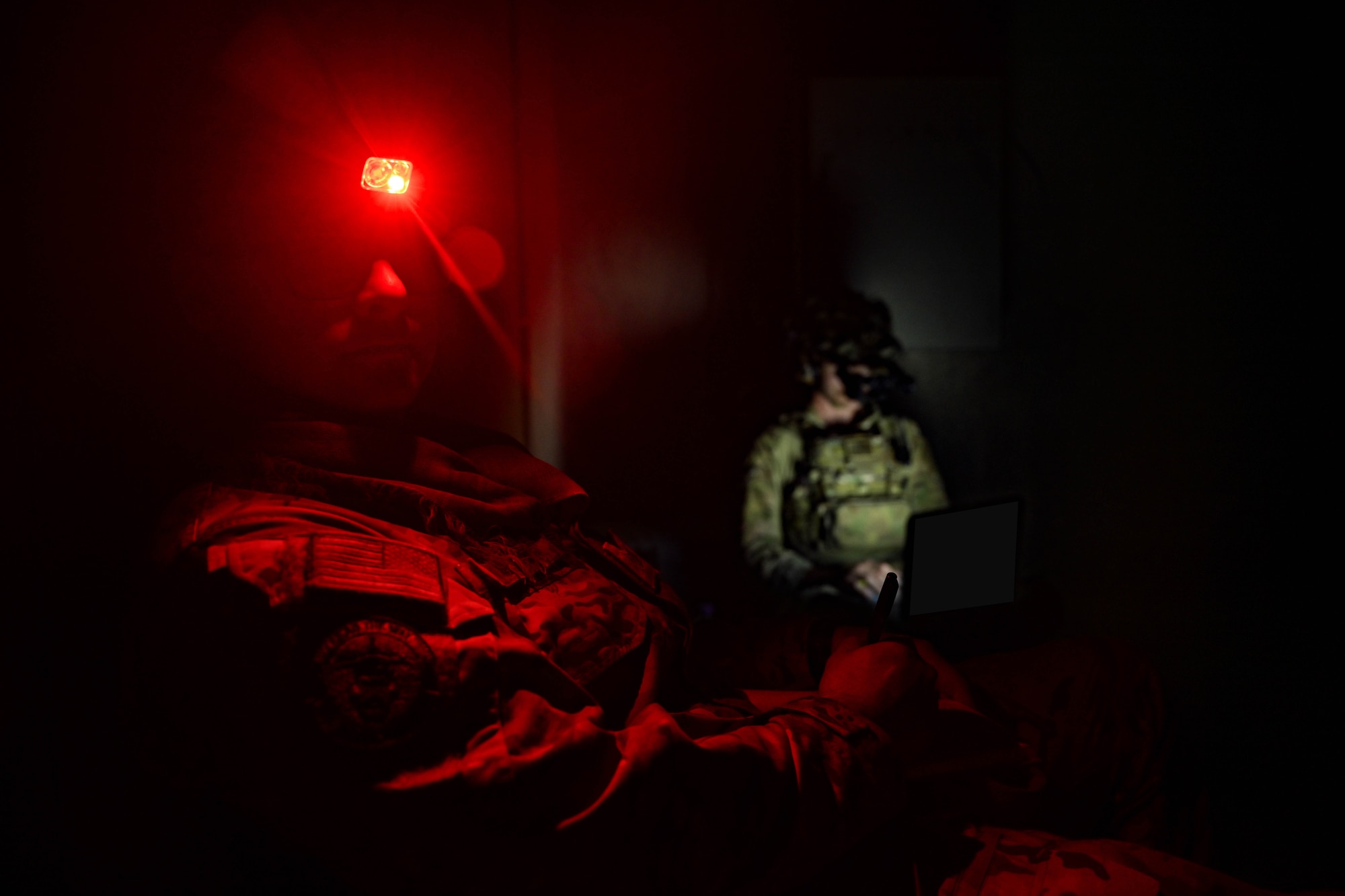 A man wearing a red headlight looks at the camera.