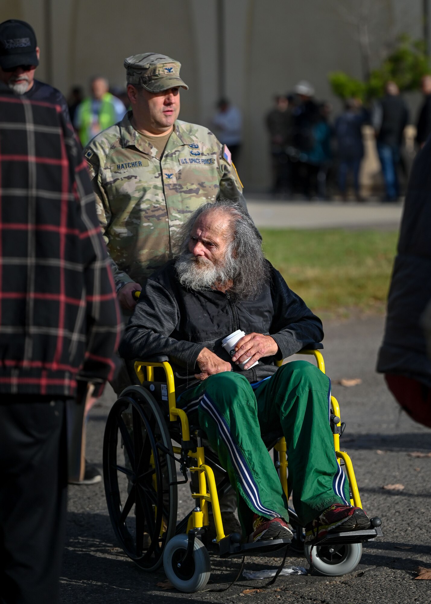 Hatcher assists a veteran in a wheelchair.