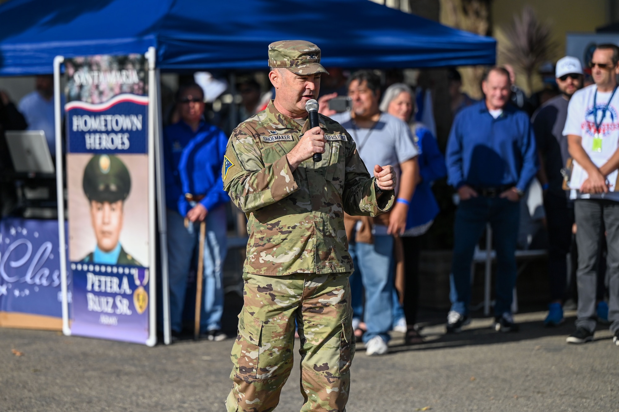 Shoemaker stands outside speaking into a microphone.