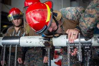 Marines practice pipe patching during  a damage control Olympics aboard USS Boxer (LHD 4) as the ship steams in the Pacific Ocean.