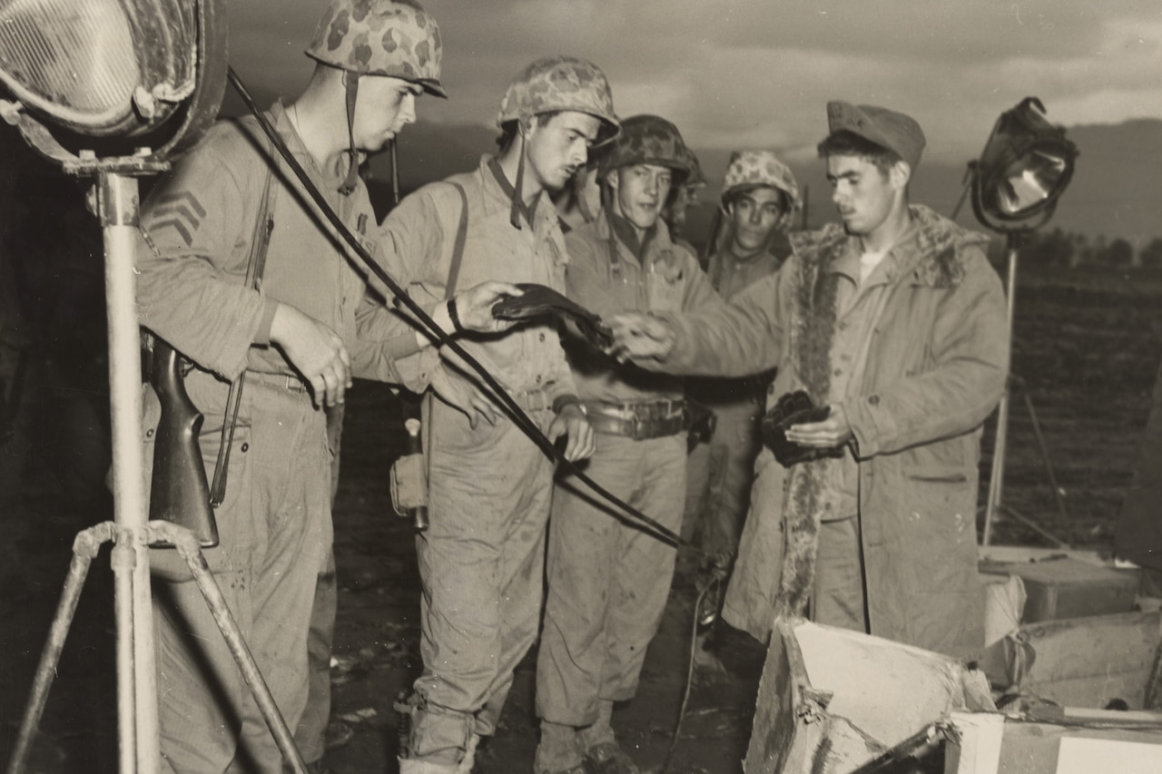 A group of Marines receive gloves and other warm clothes during the Korean War.