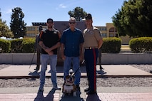 U.S. Marine Corps Sgt. Maj. John Miller, right, sergeant major of Recruit Training Regiment, Marine Corps Recruit Depot San Diego, and Lance Cpl. Bruno, the mascot for MCRD San Diego and the Western Recruiting Region, pose for a photo in front of the drill instructor monument with Terry and Dustin Bringham, the son and grandson of the late Capt. Gary L. Bringham, at MCRD San Diego, California, Oct. 21, 2024. From 1962 to 1965, Gary Bringham served as a drill instructor at MCRD San Diego before commissioning and retiring as a captain. The Bringham family toured the depot to learn more about his role as a drill instructor and the significance of training recruits. (U.S. Marine Corps photo by Cpl. Alexander O. Devereux)
