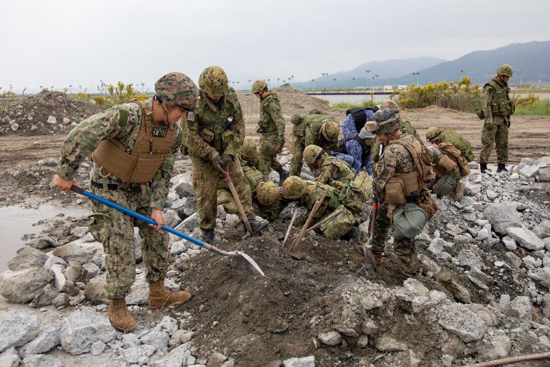U.S. Sailors with Headquarters and Headquarters Squadron, Marine Corps Air Station Iwakuni, U.S. Marines with Marine Wing Support Squadron 171, Marine Aircraft Group 12, 1st Marine Aircraft Wing, Japan Ground Self Defense Force members with 13th Brigade, Middle Army, and Japan Maritime Self Defense Force members with Fleet Air Wing 31, remove pieces of concrete from rebar while preparing a simulated airfield damage repair (ADR) site during exercise Keen Sword 25 at Marine Corps Air Station Iwakuni, Japan, Oct. 29, 2024. The purpose of the ADR was to improve the interoperability of the bilateral force in expeditious airfield and runway repair in forward-deployed, combat environments. Keen Sword is a biennial, joint and bilateral field-training exercise involving U.S. military and Japan Self-Defense Force personnel, designed to increase readiness and interoperability while strengthening the ironclad U.S.-Japan alliance. (U.S. Marine Corps photo by Sgt. Randall Whiteman)
