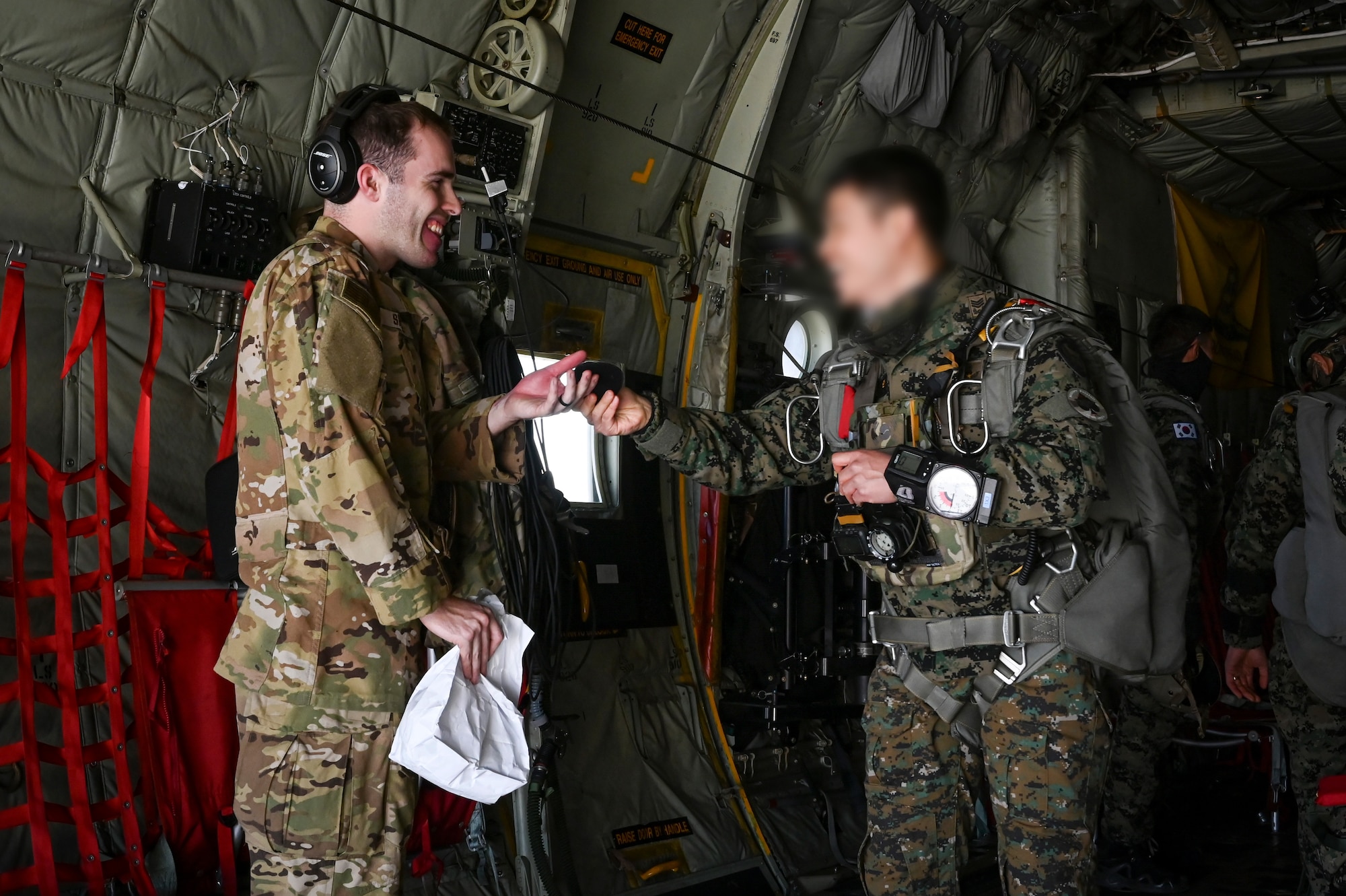 U.S. Air Force Senior Airman John Shobg, 36th Airlift Squadron C-130J Super Hercules loadmaster, exchange patches with a Republic of Korea Special Warfare Command Master Sergeant, prior to a high-altitude, high-opening proficiency jump training event for Freedom Flag 24-1 at Kunsan Air Base, Republic of Korea.