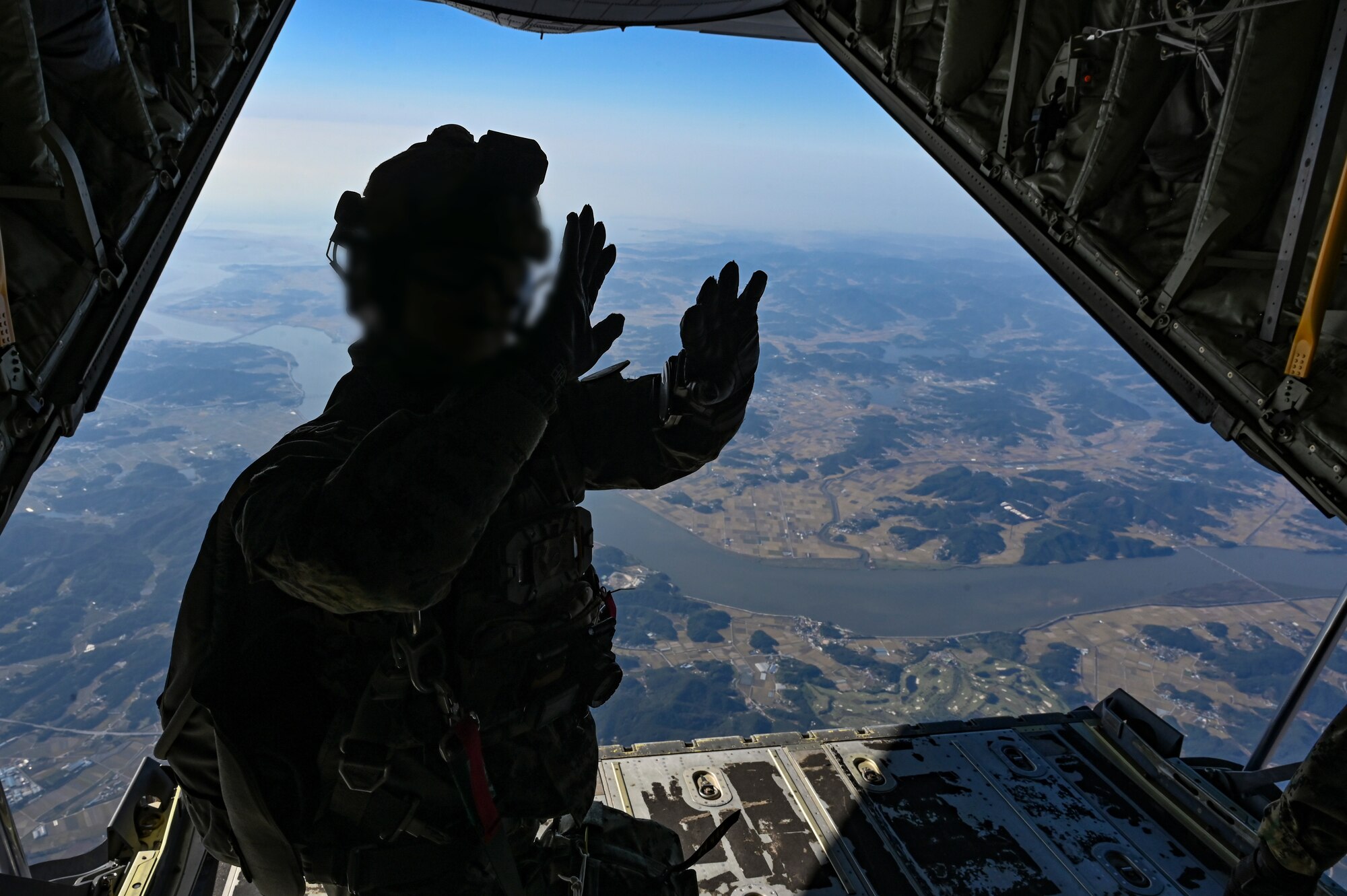 A Republic of Korea Special Warfare Command Soldier assigned to the 1st Special Forces Brigade demonstrates hand signals during a high-altitude, high-opening proficiency jump in preparation for Freedom Flag 24-1 at Kunsan Air Base, Republic of Korea.