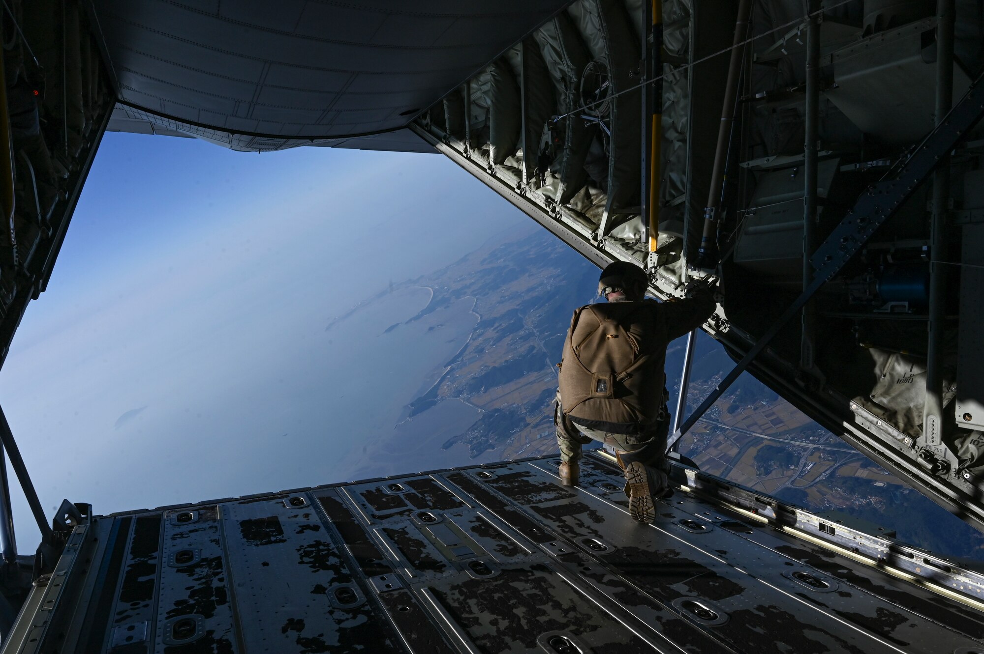 A U.S. Army Special Forces Soldier and jumpmaster assigned to the 1st Special Forces Group (Airborne), visually confirms the location of a designated drop zone during a high-altitude, high-opening proficiency jump training event in preparation for Freedom Flag 24-1 at Kunsan Air Base, Republic of Korea.