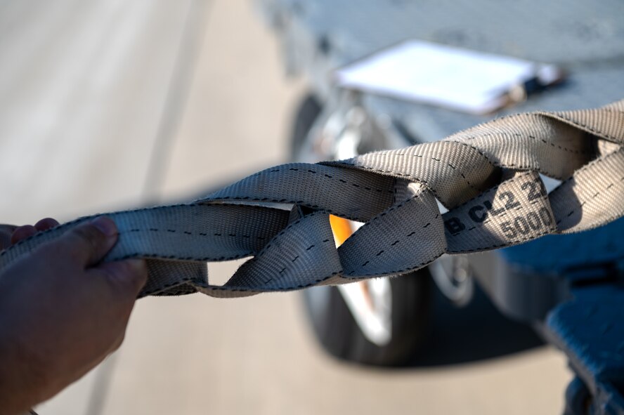 A U.S. Airman, assigned to the 4th Special Operations Aircraft Maintenance Squadron, prepares a tie-down strap after loading ammunition on board an AC-130J Ghostrider gunship at Hurlburt Field, Florida, Oct. 23, 2024.