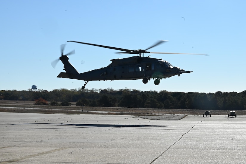 A helicopter flies low over a tarmac.