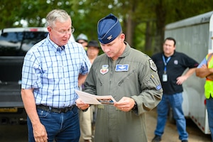 Col. Walker and Mr. Muszynski stand side by side looking at a diagram.