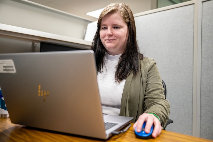 A woman types on a laptop.