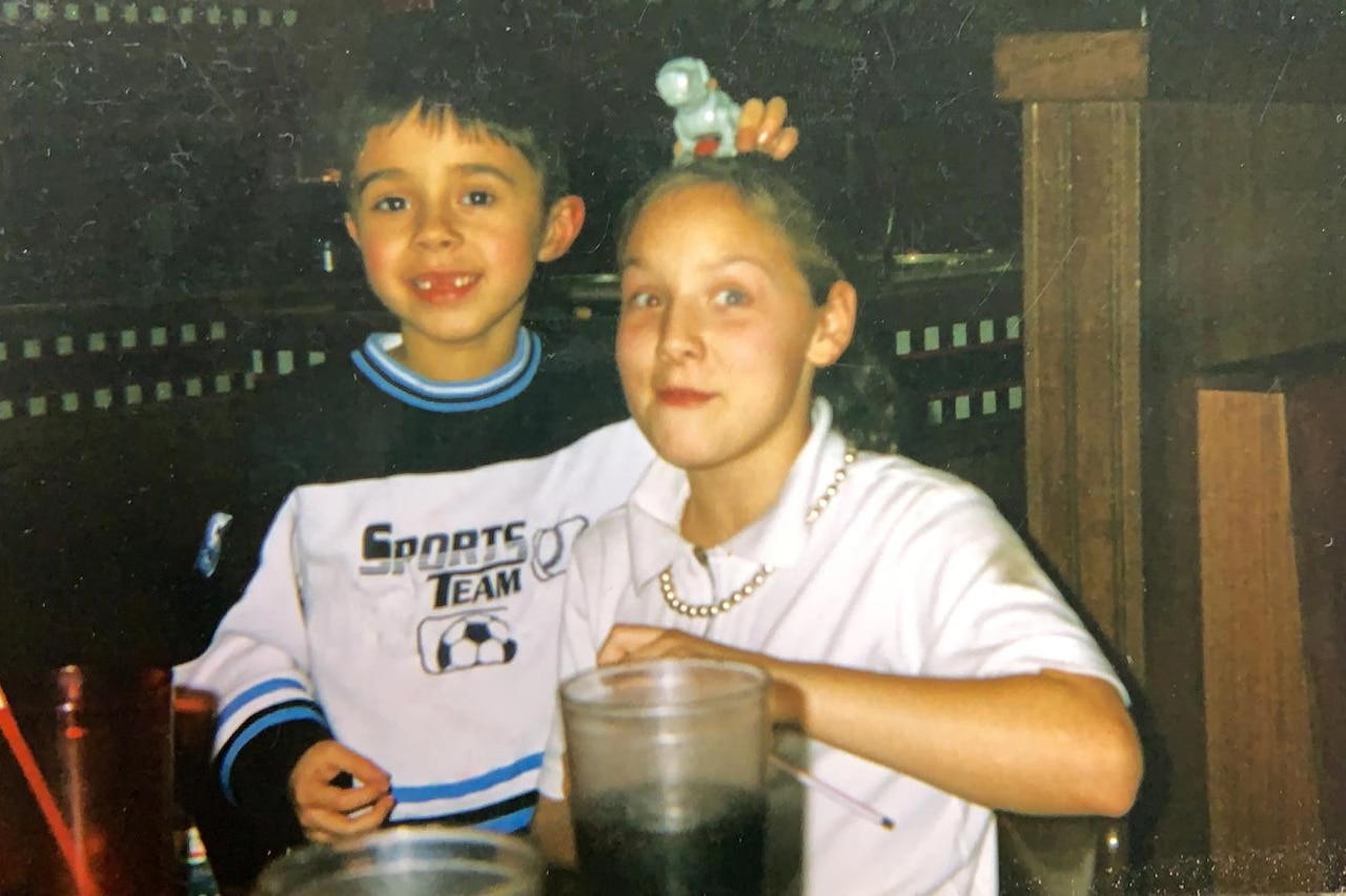 A child sits with an adult at a restaurant.
