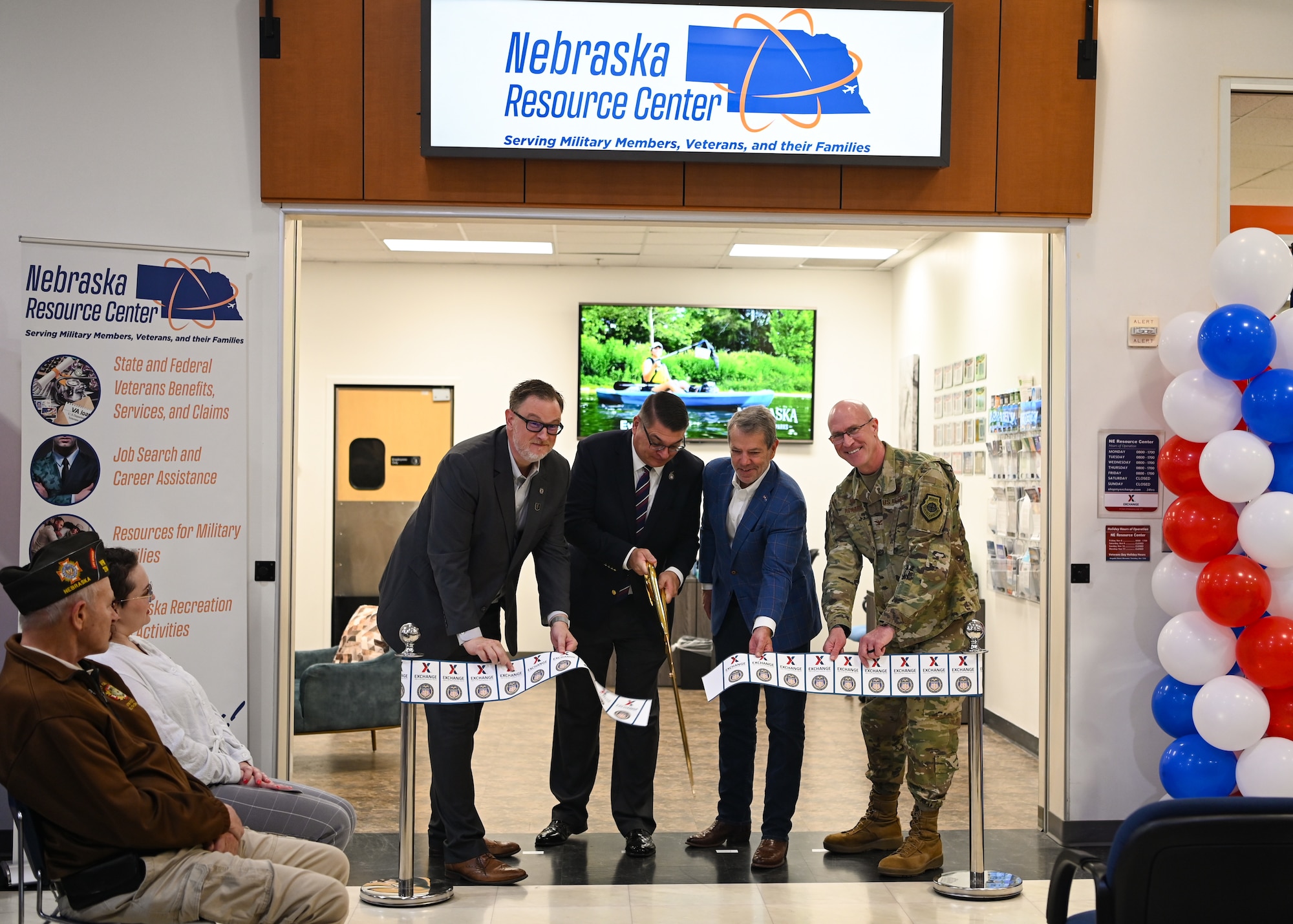 People pose for photo while cutting ribbon.