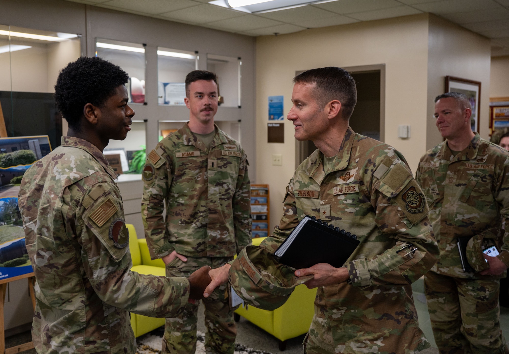 U.S. Air Force Airman 1st Class Eric Philips, 628th Communications Squadron security operations technician, receives a coin from Brig. Gen. Stephen Snelson, U.S. Air Force Expeditionary Center commander, during a visit to Joint Base Charleston, South Carolina, Oct. 29, 2024. During their visit, Snelson and Fuselier gained insight into JB Charleston’s vital contributions to global mobility, rapid deployment, and joint operations. (U.S. Air Force photo by Senior Airman Christian Silvera)