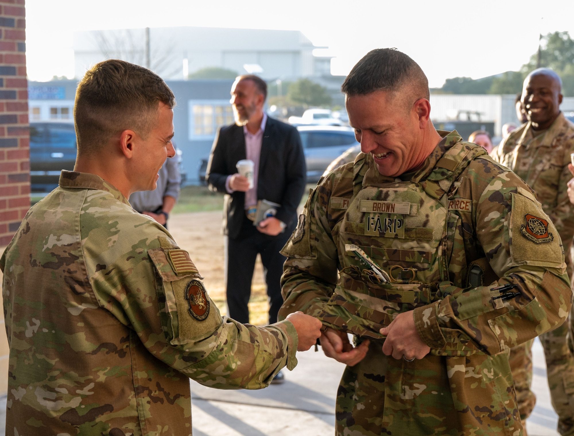 U.S. Air Force Senior Airman Joseph Barber, 628th Logistics Readiness Squadron petroleum, oil and lubricant journeyman, assists Chief Master Sgt. Dennis Fuselier, U.S. Air Force Expeditionary Center command chief, to put on a kevlar vest during a forward area refueling point mission brief at Joint Base Charleston, South Carolina, Oct. 30, 2024. The USAFEC command team engaged with Airmen and Sailors across the installation, observing firsthand their innovative approaches to enhancing mission success and operational readiness. (U.S. Air Force photo by Senior Airman Christian Silvera)