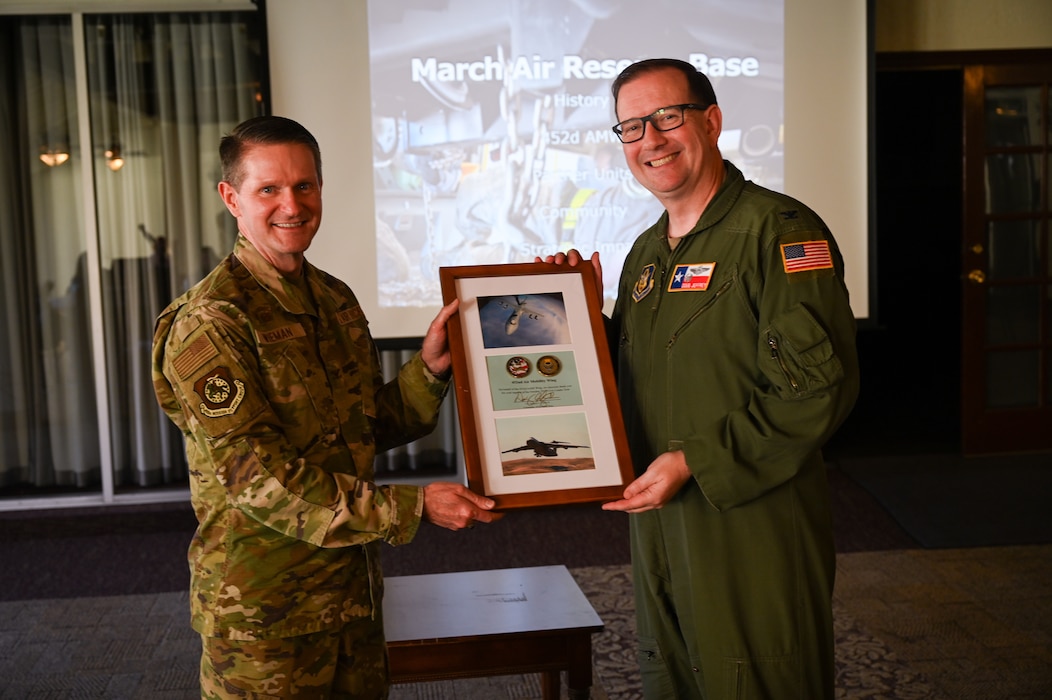 Col. Douglas C. Jeffrey, IV, 433rd Airlift Wing commander, presents a gift from the 433rd AW to Col. Robert Wieman, 452nd Mission Support Group commander, for his brief about the 452nd Air Mobility Wing and for hosting 16 Greater San Antonio area civic leaders for a tour at March Air Reserve Base, Calif., Oct. 24, 2024.