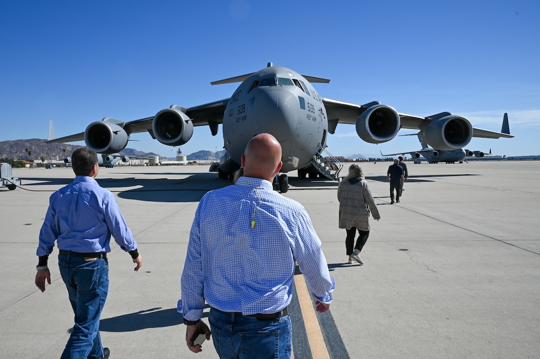 Greater San Antonio area civic leaders walk across a flightline to tour inside a C-17 Globemaster III at March Air Reserve Base, California, Oct. 24, 2024.