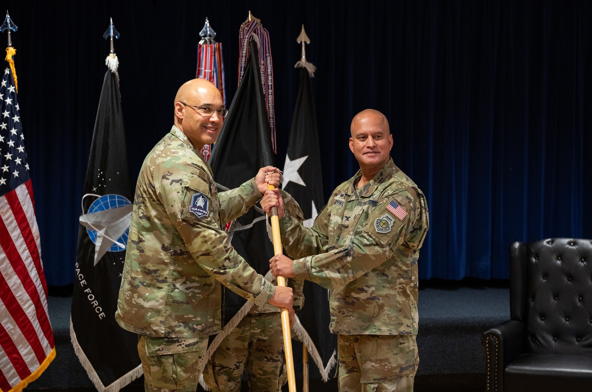 U.S. Space Force Lt. Gen. David N. Miller, Jr., Space Operations Command commander passes the Mission Delta 2 guidon to U.S. Space Force Col. Raj Agrawal, MD 2 commander, during a redesignation ceremony, Oct. 31, 2024. Mission Deltas oversee all aspects of mission area functions – people, training, equipment and combat sustainment.