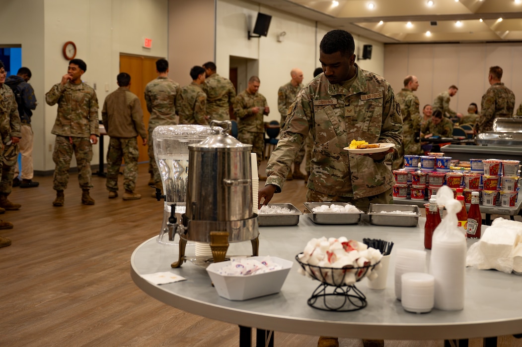 A U.S. Air Force Airman assigned to the 51st Fighter Wing grabs utensils from an alternate dining facility during Beverly Herd 25-1 at Osan Air Base, Republic of Korea, Nov. 1, 2024. The alternate DFAC, operated by the 51st Force Support Squadron, can be implemented in contingent scenarios and in various locations to ensure Airmen remain fed and mission-ready. (U.S. Air Force photo by Senior Airman Brittany Russell)