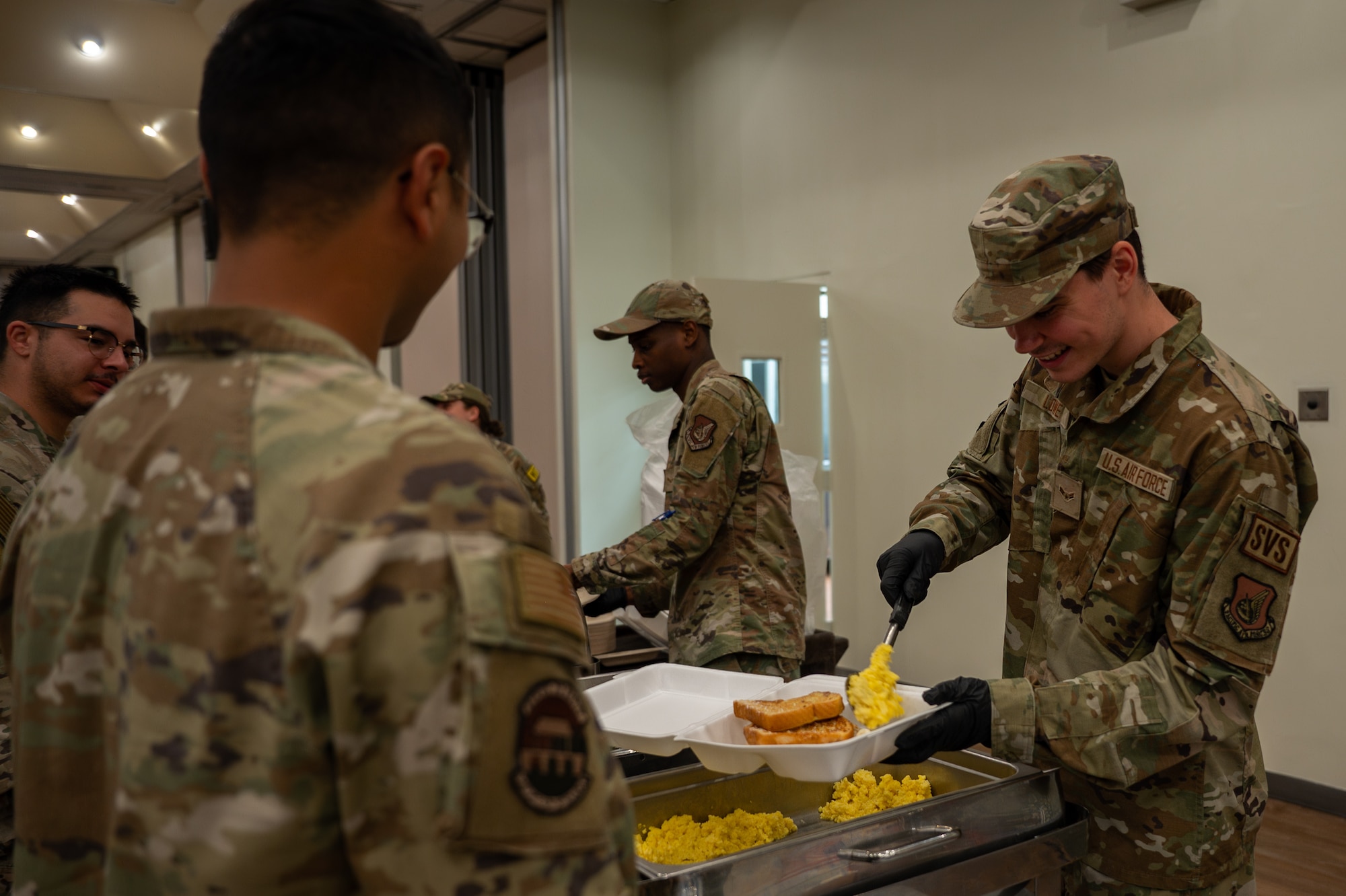 A U.S. Air Force Airman assigned to the 51st Force Support Squadron serves meals from an alternate dining facility during Beverly Herd 25-1 at Osan Air Base, Republic of Korea, Nov. 1, 2024. An alternate DFAC ensures Airmen stay fueled and ready to “Fight Tonight,” no matter the contingent circumstances. (U.S. Air Force photo by Senior Airman Brittany Russell)