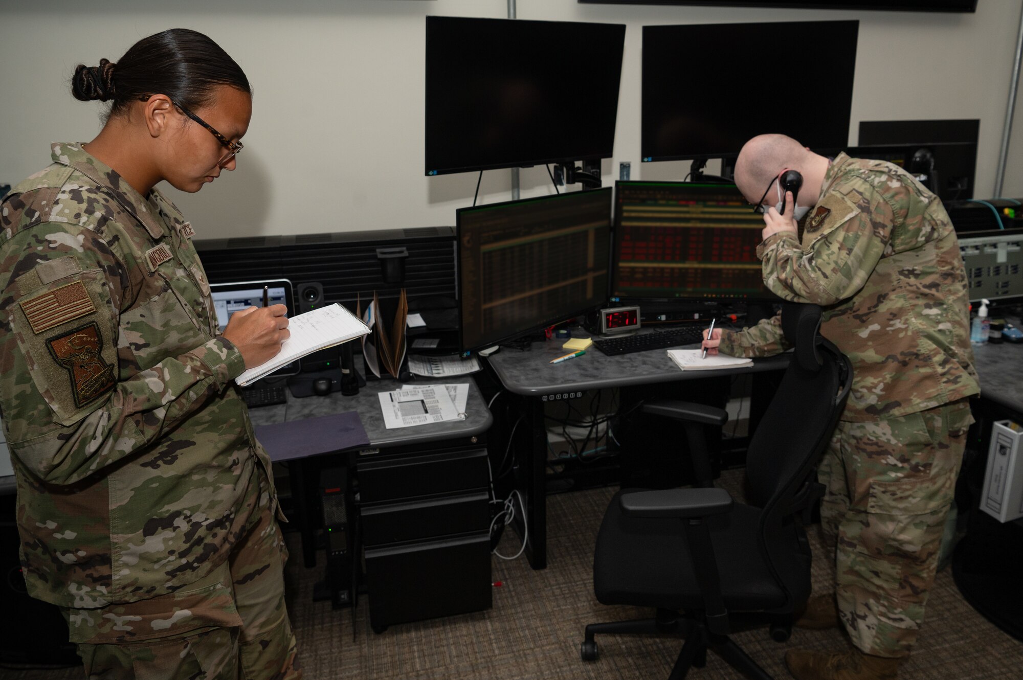 Airman 1st Class Cheyenne Wallowingbull, 36th Command Post junior emergency actions controller, assists Senior Airman Andrew Vance, 36th Command Post senior EAC, in the command and control center at Andersen Air Force Base, Guam, Oct. 29, 2024. Essentially, Command Post upchannels and downchannels information 24/7. Anything from an injuries or damage to property, up to force protection conditions changes, or National Security updates that affect the base. They get almost all information and disseminate it accordingly. (U.S. Air Force photo by Staff Sgt. Pedro Tenorio)