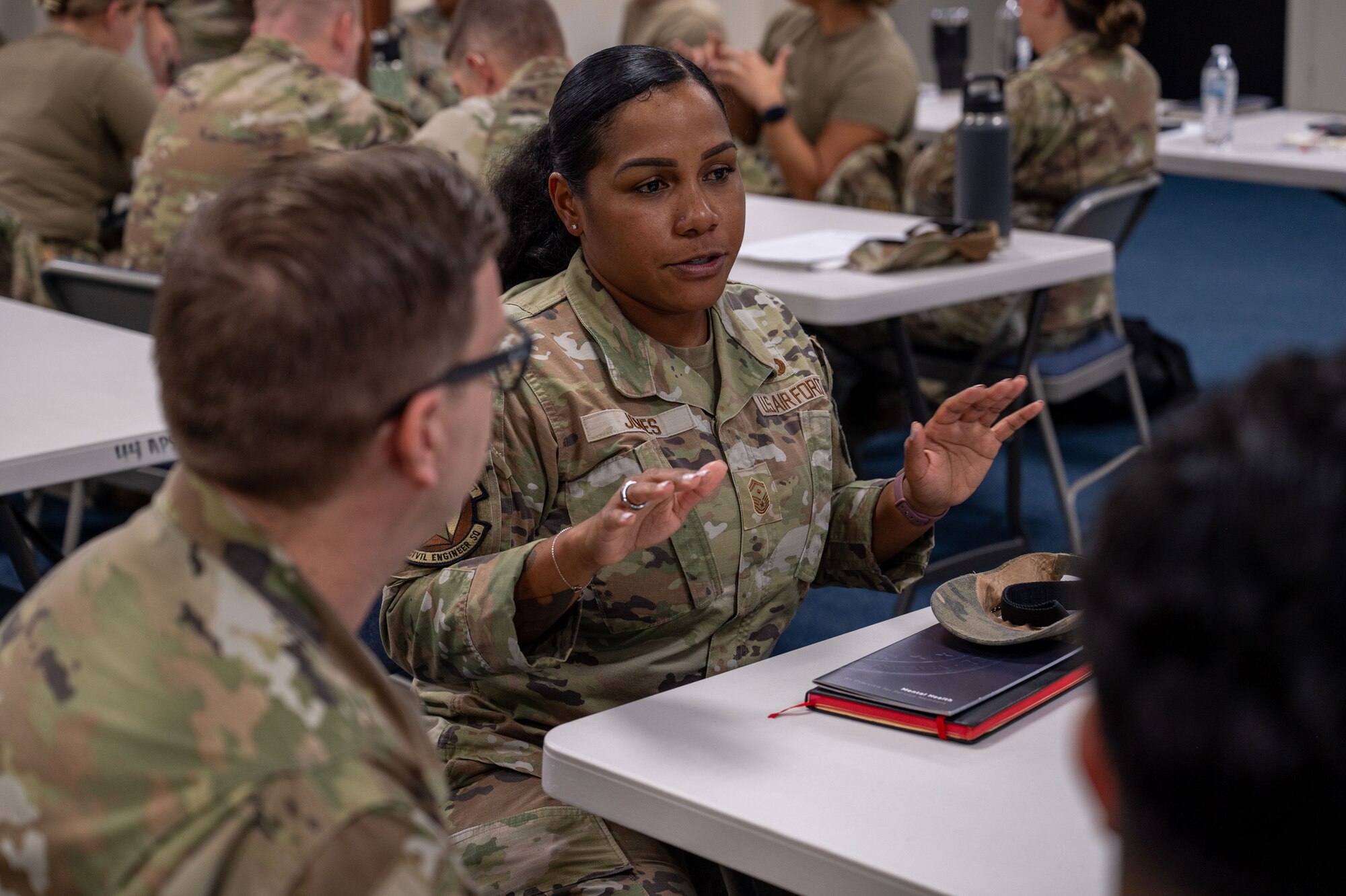 U.S. Air Force Master Sgt. Jeremy Hamblin, 644th Combat Communications Squadron first sergeant, and Tech. Sgt. Joselle San Miguel, 36th Logistics Readiness Squadron inbound cargo noncommissioned officer in charge, discuss what to do during a potential scenario during a First Sergeant Symposium at Andersen Air Force Base, Guam, Oct. 28-31, 2024. The symposium was held to train Technical Sergeants and above on how to be an interim first sergeant when current first sergeants are unavailable. (U.S. Air Force photo by Audree Campbell)