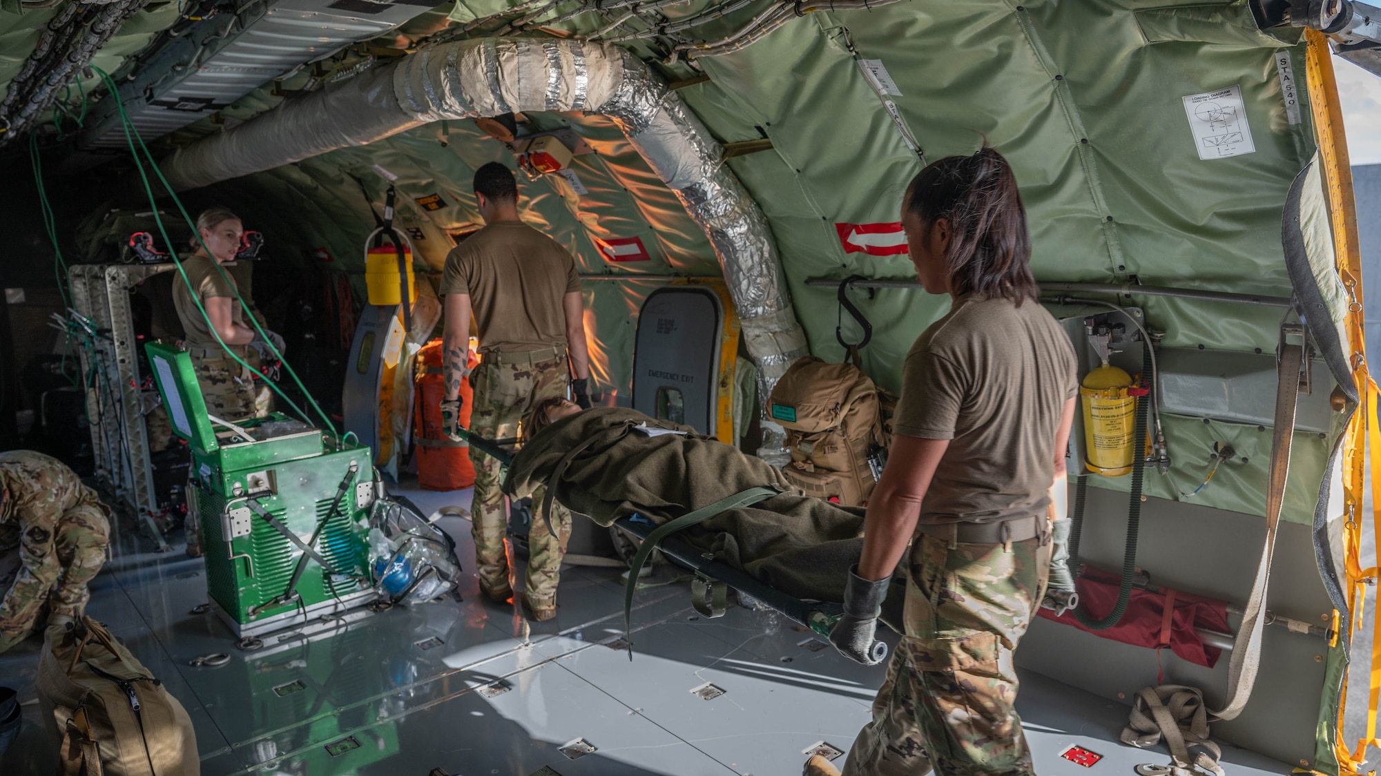 Two  Airman from the 18th AES load a simulated paitent